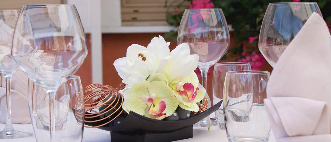 Table dressée, verres et fleurs blanches
